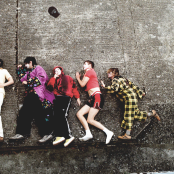 Members of the band 'Sorry' lying down on a concrete floor.